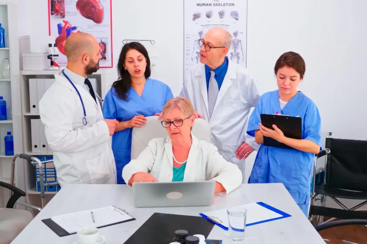 Medical specialists collaborating around a laptop
